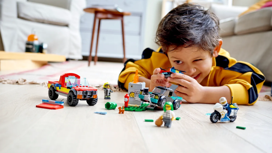 Um menino brincando com legos no chão