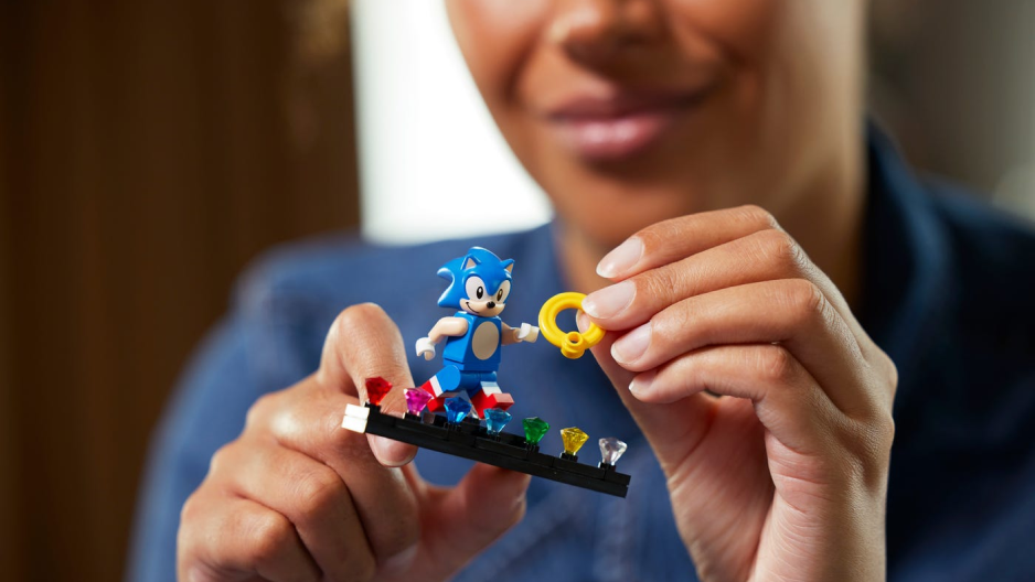 Uma mulher brincando com um brinquedo lego do sonic